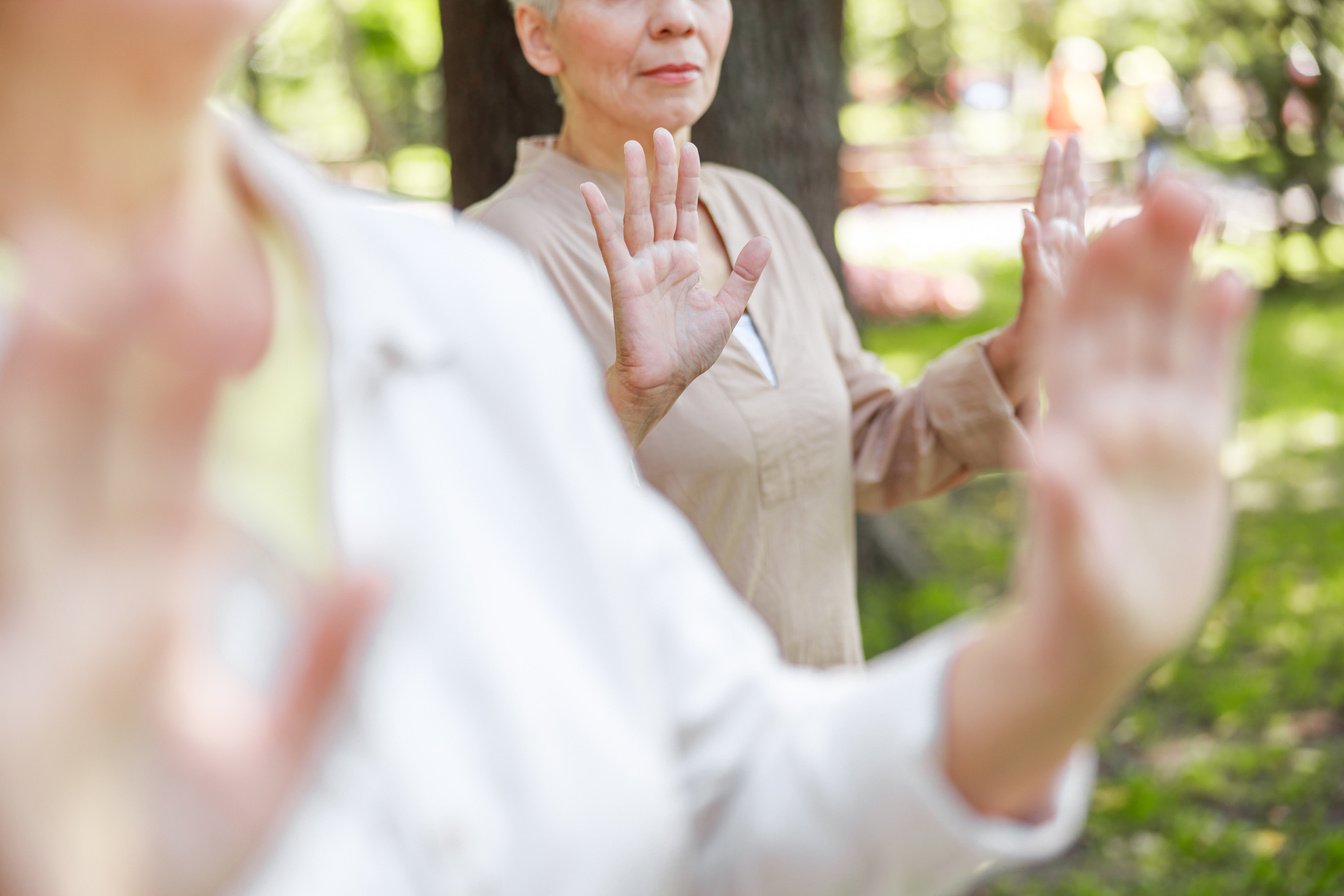 Old woman doing qigong exercise in the park